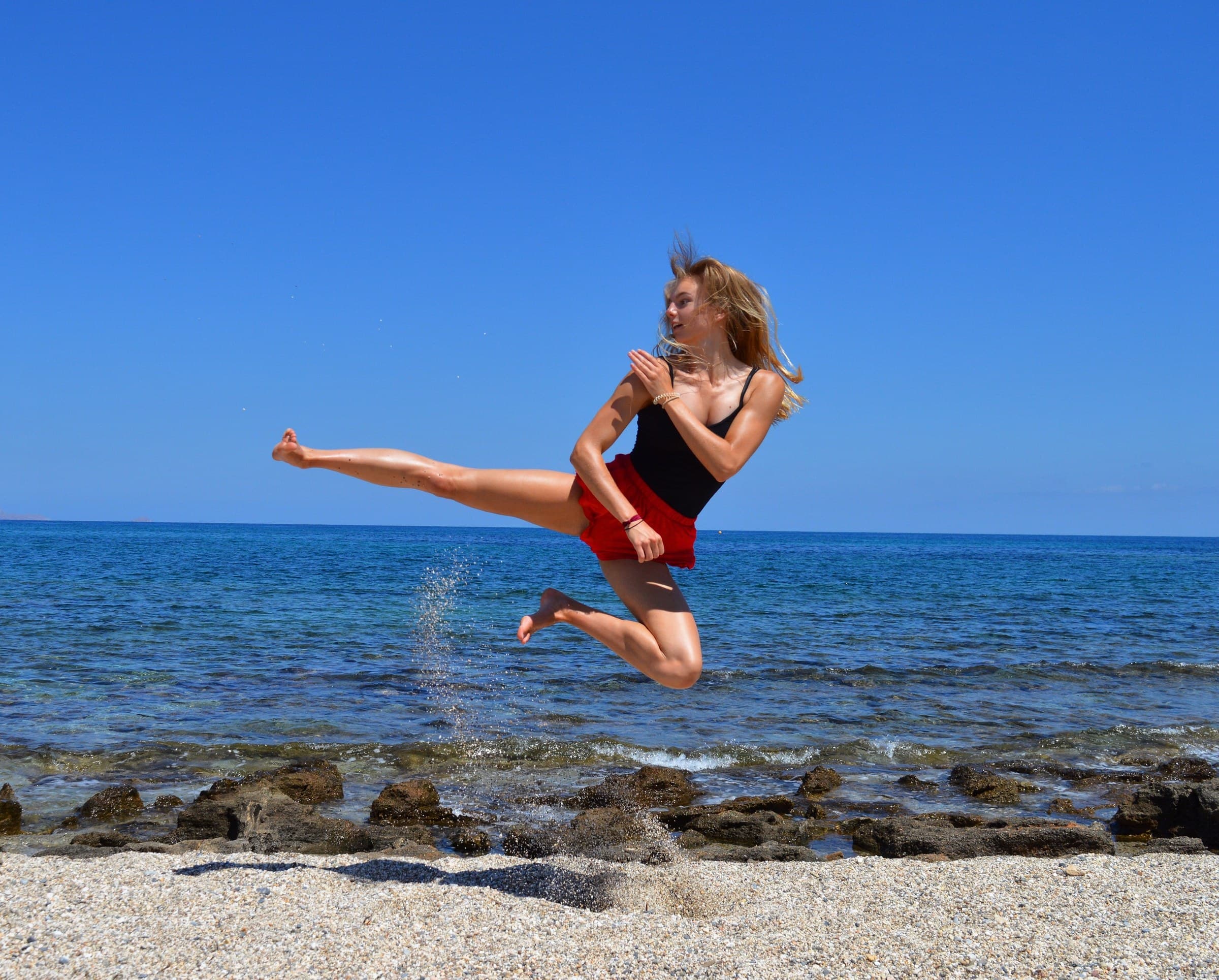 Kira Wirz beim Taekwondo-Kick am Strand – Online Fitness-Coaching verbindet Leistungssport mit Psychologie